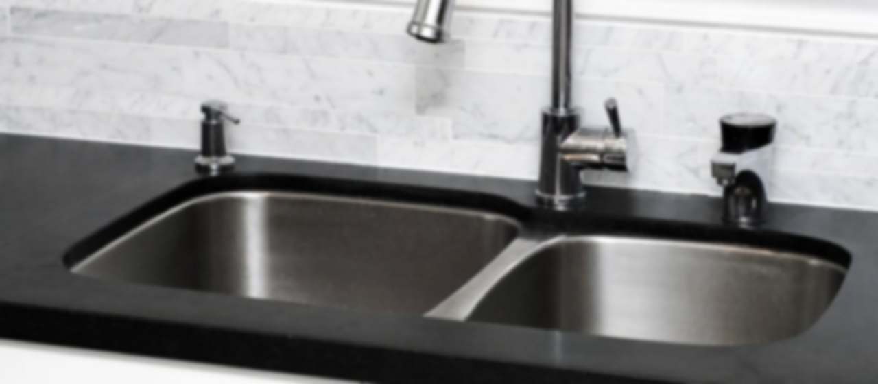 Fregadero doble de acero inoxidable con grifo extraíble en una encimera de cocina