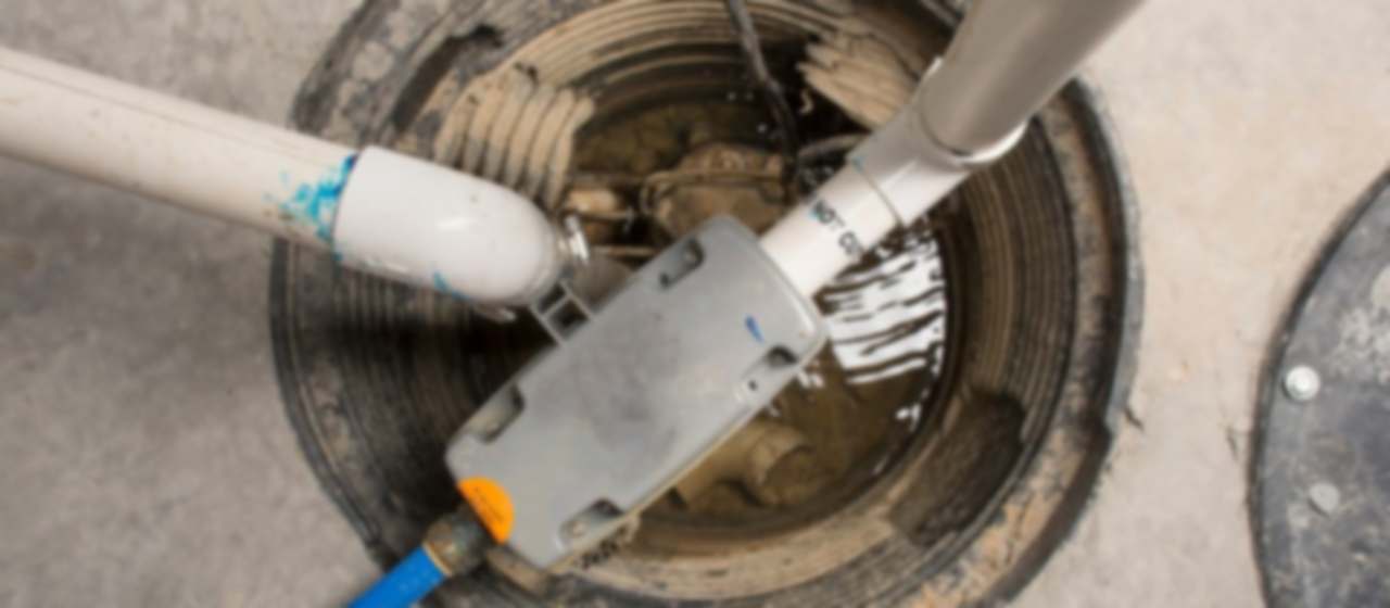Pozo de bombeo abierto con la bomba de achique y las tuberías de impulsión de aguas residuales